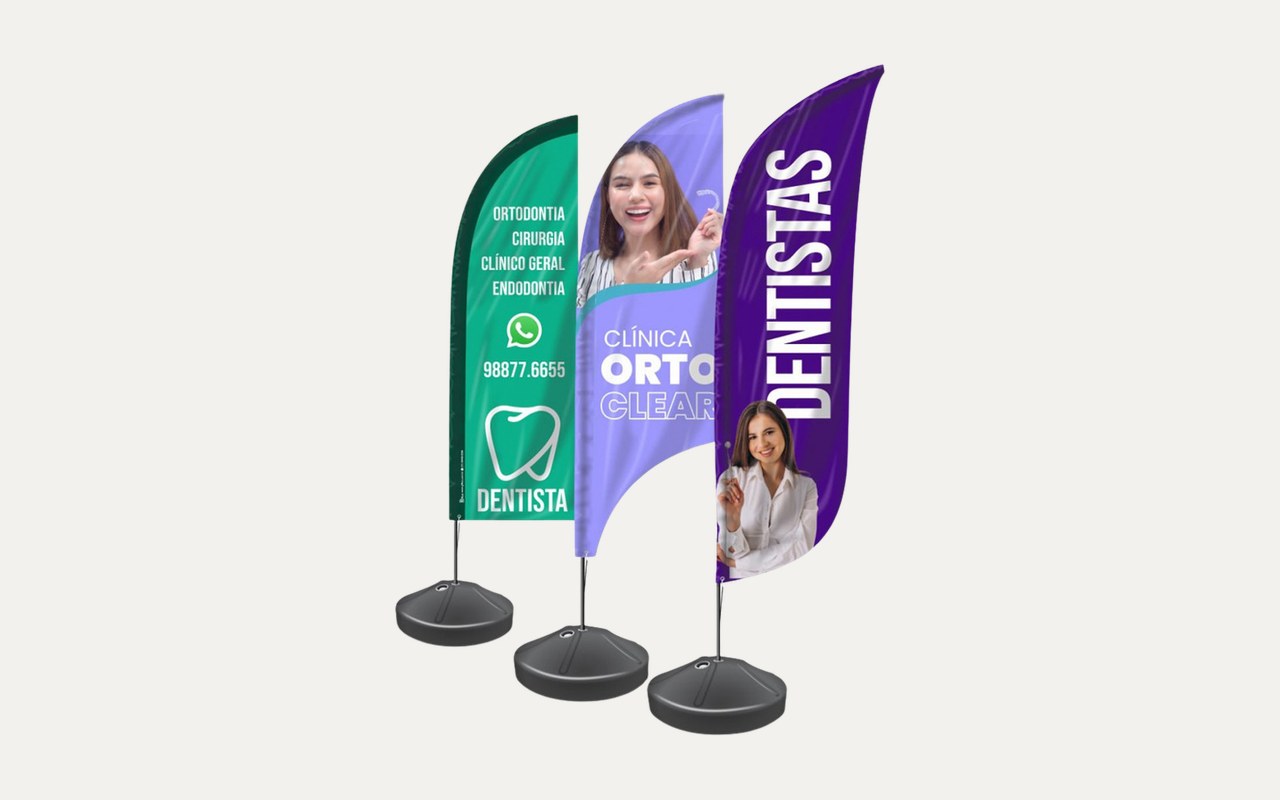 Três wind banners montados com haste e base, um ao lado do outro